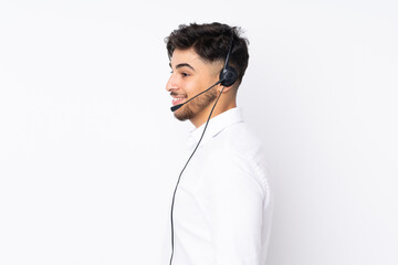 Telemarketer Arabian man working with a headset isolated on white background looking to the side