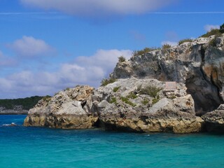 Fototapeta na wymiar Boulders of rocks hiding the Thunderball Grotto in the blue waters of Exuma Cays, Bahamas. The location is a popular destination and has been used for filming several movies.