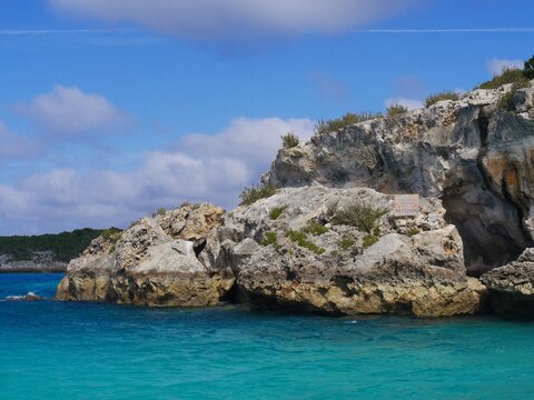 Boulders of rocks hiding the Thunderball Grotto in the blue waters of Exuma Cays, Bahamas. The location is a popular destination and has been used for filming several movies.
