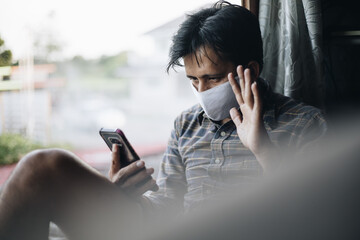 Asian man facetime video calling with smartphone at home