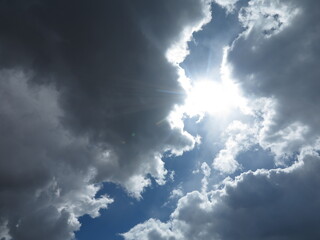 Sun breaks through clouds in blue sky