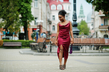 Portrait of a beautiful natural young African woman with afro hair. Black model in red silk dress.