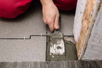 A man puts cement with a spatula for laying tiles. Finishing is one of the stages of repairing an apartment. Hands in the process.