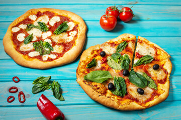 Homemade pizza margarita with mozzarella, tomatoes and basil on the blue wooden background