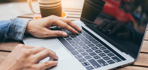 using computer.hand typing keyboard laptop online chatting search form internet while working sitting at coffee shop.concept for.technology device contact communication business people