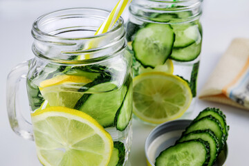 Cold drink, two retro glass cup of lemonade with cucumber and lemon on a white background, shallow depth of field, selective focus. Health drink concept.
