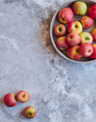 Organic apples in a bowl in gray marble surface