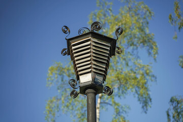 
street lamps in the afternoon in parks against the sky and trees
