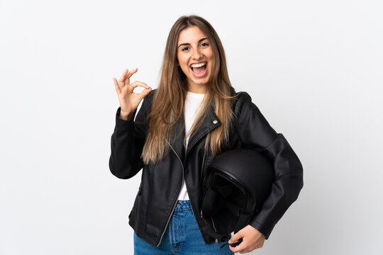 Young Woman holding a motorcycle helmet over isolated white background showing an ok sign with fingers