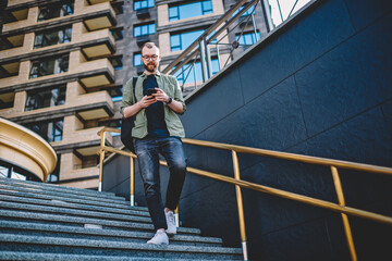 Young man in eyeglasses calling on smartphone in roaming during trip