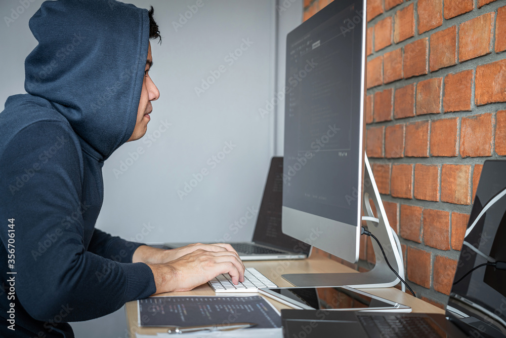 Aufkleber Computer hacker or cyber attack concept, Dangerous hooded hacker using multiple computers typing bad data into online system the access with a virus to infect steal information