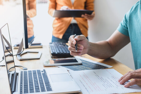 Programmers cooperating at Developing programming and website working in a software develop company office, writing codes and typing data code, Programming with HTML, PHP and javascript