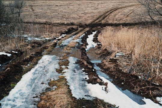 country road in early spring with snow in March, snow on the road