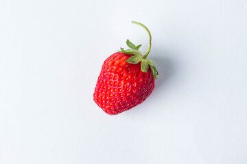 One strawberry on a white background. Photo from above. Creative photo of strawberries