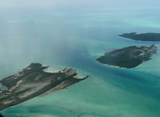 Beautiful blur of bigger islands in the Exuma Cays Bahamas seen from an airplane window.