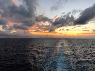 Breathtaking sunset in the Caribbean sea with a path in the water created by a cruise ship