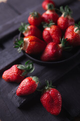 Fresh ripe strawberries on a black wooden background