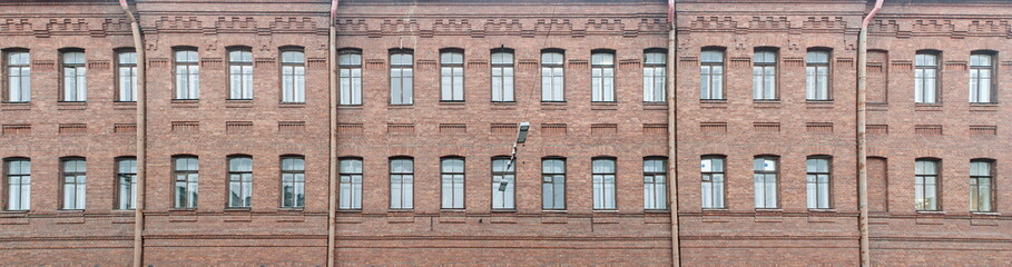 Fototapeta na wymiar Facade of an old brick residential building after reconstruction. Panorama.