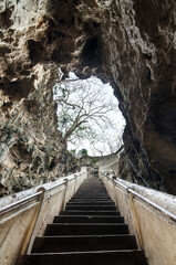 Stairway leading to the cave mouth at the entrance Tham Khao Luang temple cave , Phetchaburi, Thailand