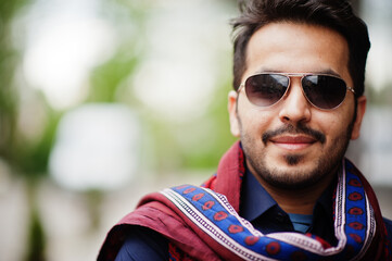 Stylish pakistani indian muslim arabic man in kurta dhoti suit and sunglasses.