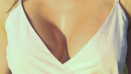 Close up of a young woman in a t-shirt with shaking breast 