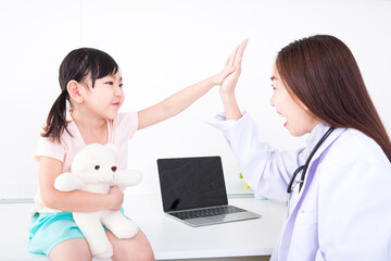 The girl patients and doctor put their hand together. female doctor is using a stethoscope. The doctor examines the flu girl in a white examination room with a laptop.