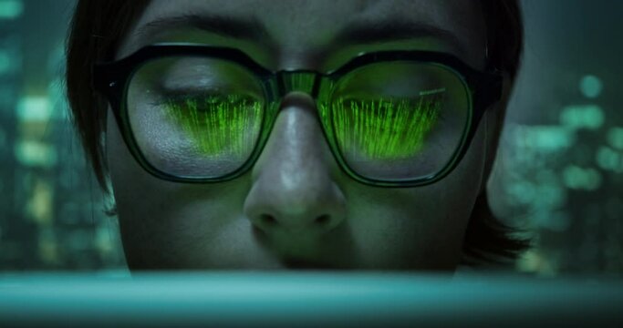 Pretty woman working on laptop wearing eyes glasses with programming matrix source code and cyberspace symbols reflection. Virtual reality matrix concept.