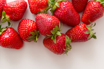 a lot of fresh strawberries on a white background top view