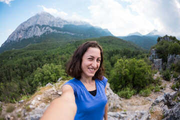 Naklejka premium A woman takes a selfie on top of a mountain.