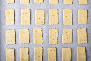 Raw cookies cut of dough on the oven tray. Top view