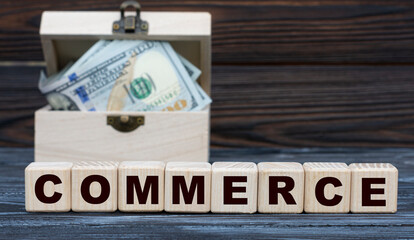 COMMERCE word on cubes with a chest of money against a dark background