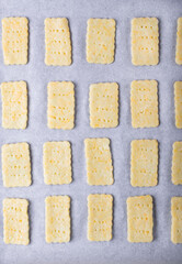 Raw cookies cut of dough on the oven tray. Top view