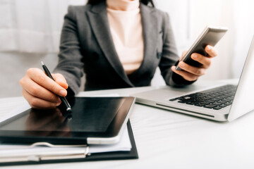 businesswoman hand working with laptop computer, tablet and smart phone in modern office with virtual icon diagram at modernoffice in morning light