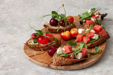 Delicious healthy breakfast, fruit sandwiches with cheese, watermelon, cherries and herbs.Summer...
