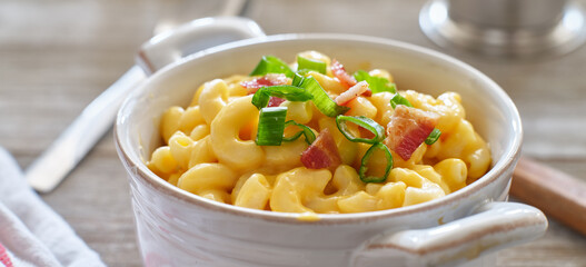 mac and cheese in dish with scallions and bacon garnish