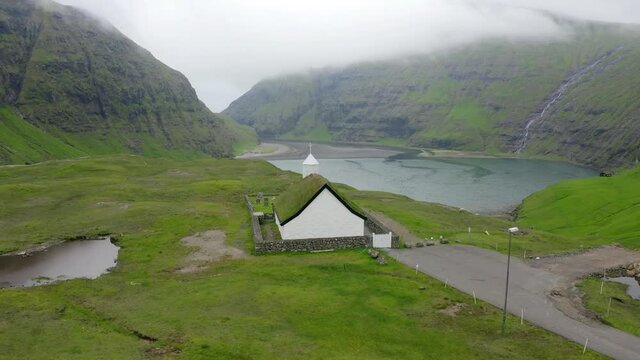 4k point of view video (Ultra High Definition) of Saksun village with Saksunar Kirkja church. Green fresh morning scene of pasture near Pollurin Laguna, Faroe Islands, Denmark, Europe. 