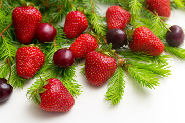 fresh strawberries in the branches of pine needles, creative Christmas background