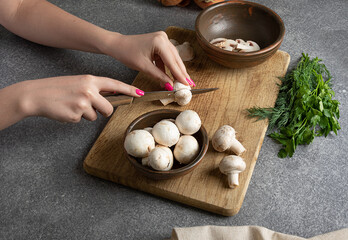 female hands cut mushrooms for  vegan dish. Detox diet. Diet mushroom dish with dill.
