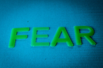 Fear. Word made by green letters on blue background.
