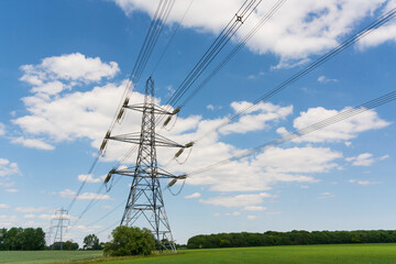 Electricity pylons in a field with blue sky. Much Hadham. Hertfordshire. UK