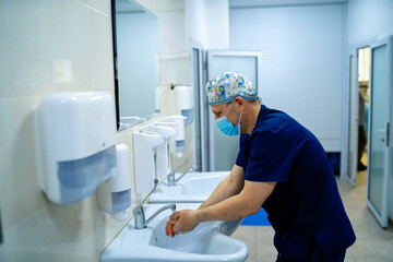Obraz premium Surgeon in hospital washing hands thoroughly before performing a surgery.