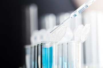 microbiological pipette in the genetic laboratory. study of a virus or vaccination. blue tinted.