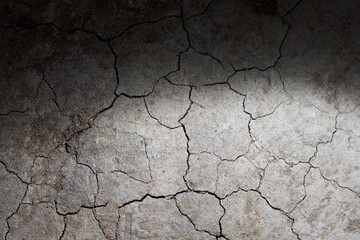 Dry cracked earth ground texture with spot light. No watering desert.