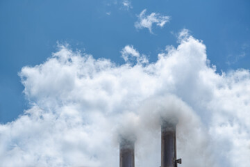 Smoke and steam produced off from the chimney against dark stormy sky,industrial smoke from chimney on blue sky.