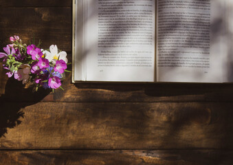 open book and vase on wooden table