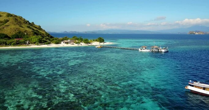  Aerial view of a beautiful island with an idyllic beach and a large barrier coral reef, in Asia, Indonesia, Kanawa island near Flores