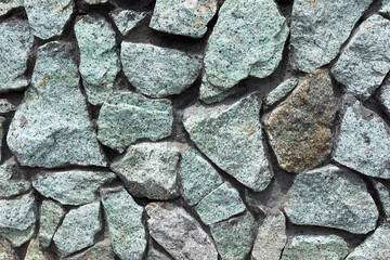 Fototapeta premium a fragment of a gray-blue stone wall for the background or texture.