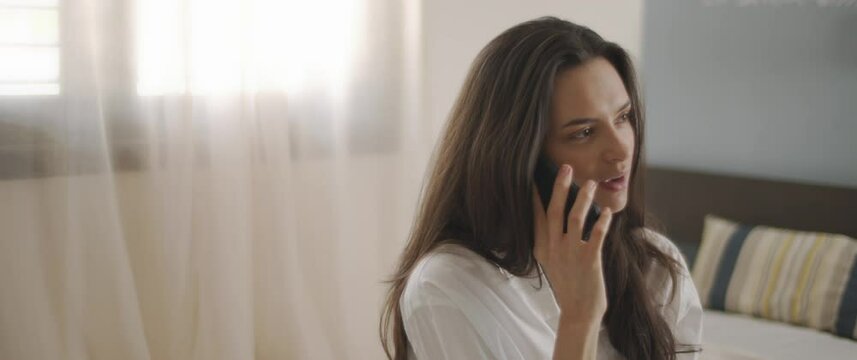 Close up of a woman in white shirt talking to someone on the phone, smiling. Slow motion, BMPCC 4K