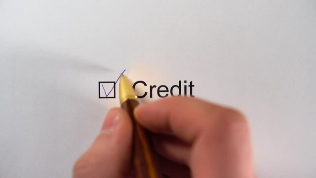Man writing a tick in checkbox CREDIT on white paper. Credit Worthiness