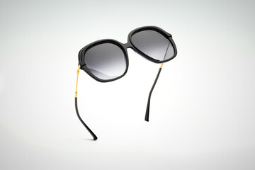 Sunglasses black of flying on white and grey background. Sun glasses summer woman accessories as...